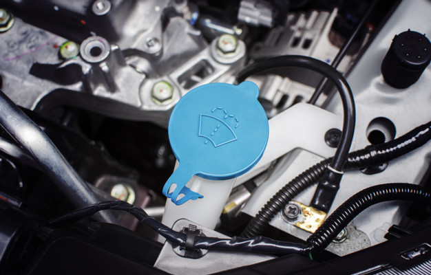 Windshield washer fluid cap with blue color in engine room of ca
