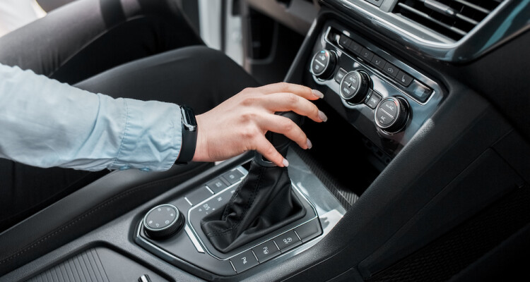Business woman holds her hand on the gear selector automatic transmission